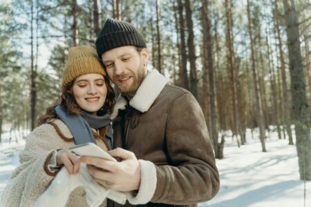 Person checking weather app on smartphone with cloudy sky background