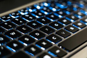 Person typing on laptop keyboard for content creation