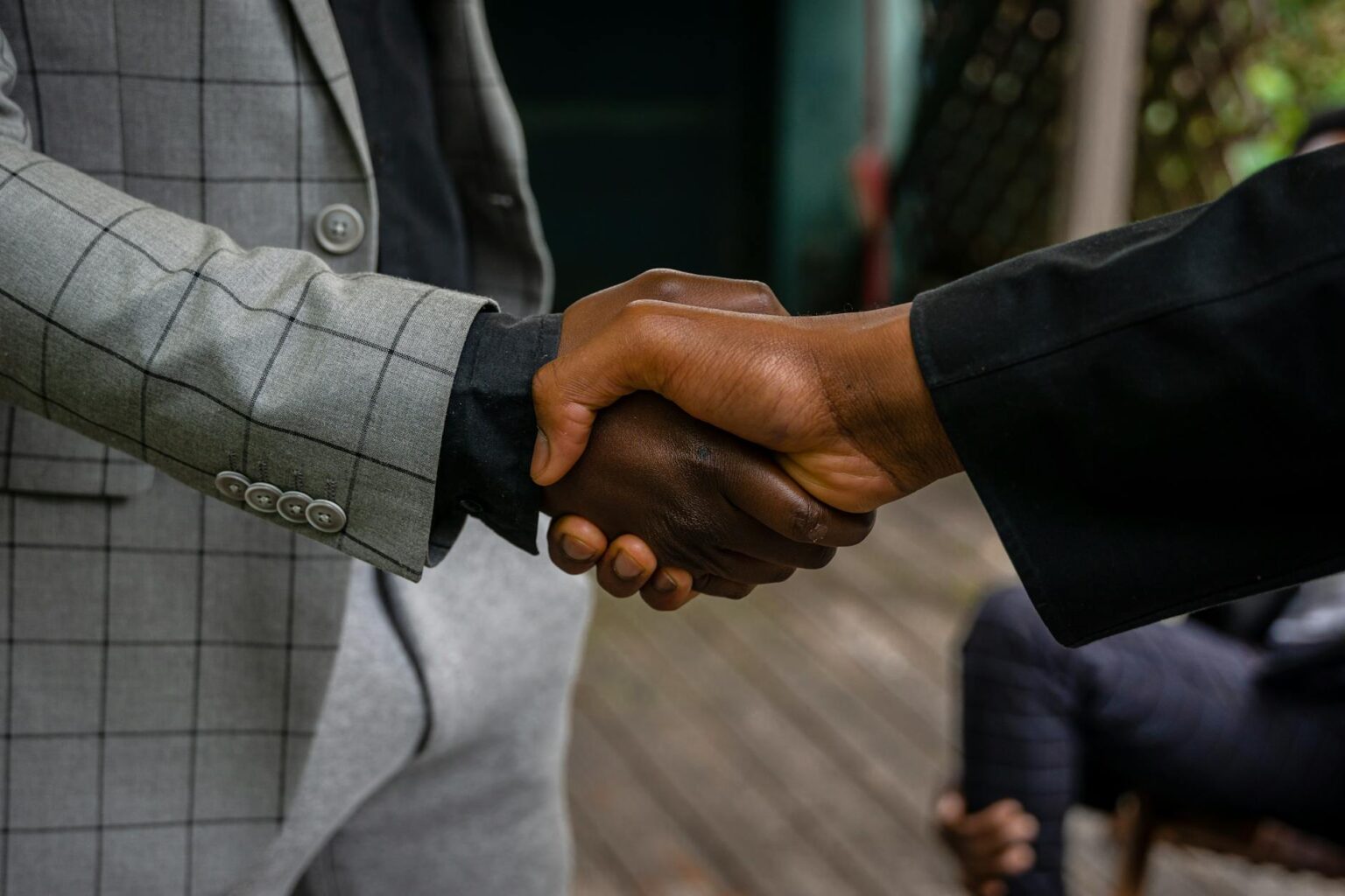 Two people shaking hands in a professional business meeting, symbolizing trust and agreement