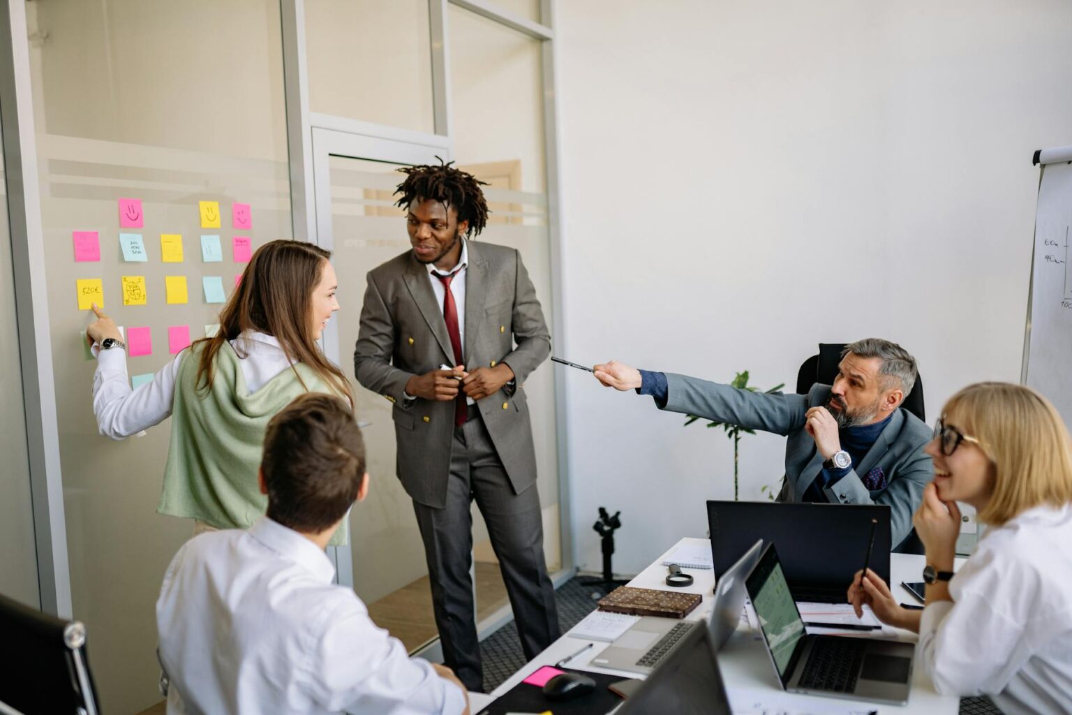 Group of people collaborating around a whiteboard with sticky notes and ideas