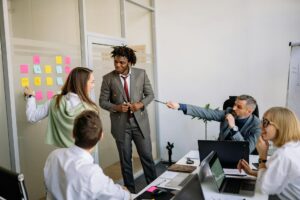 Group of people collaborating around a whiteboard with sticky notes and ideas