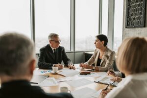 Professionals engaged in animated discussion around conference table during team meeting