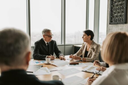 Professionals engaged in animated discussion around conference table during team meeting
