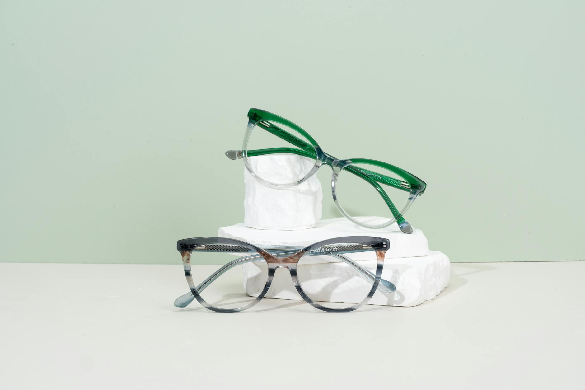 Multiple eyeglass frames displayed on a clean surface showing variety of styles