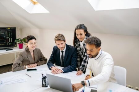 Business team collaborating around laptops in modern office setting