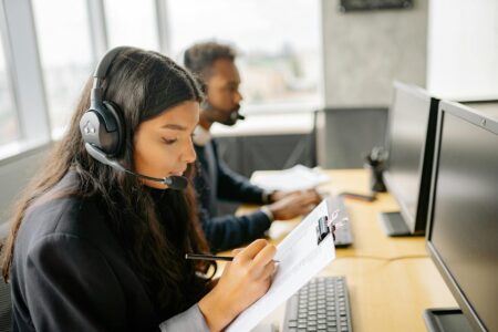 Professional customer service representative wearing headset while working at computer