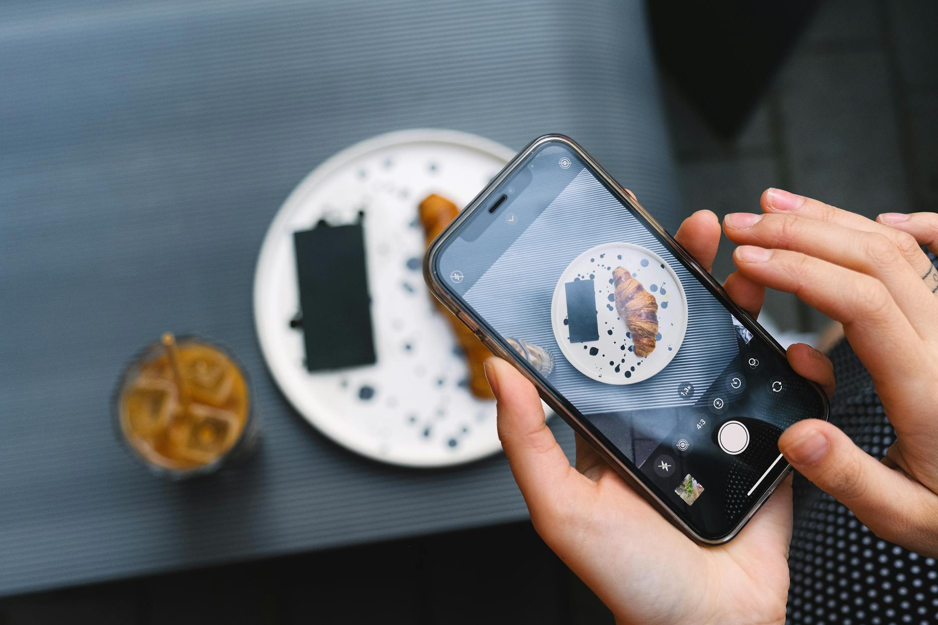 Person holding smartphone while ordering coffee, representing mobile ordering convenience