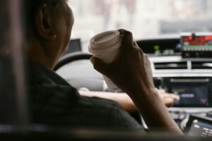 Cars lined up at a busy coffee shop drive-thru window with barista serving customers