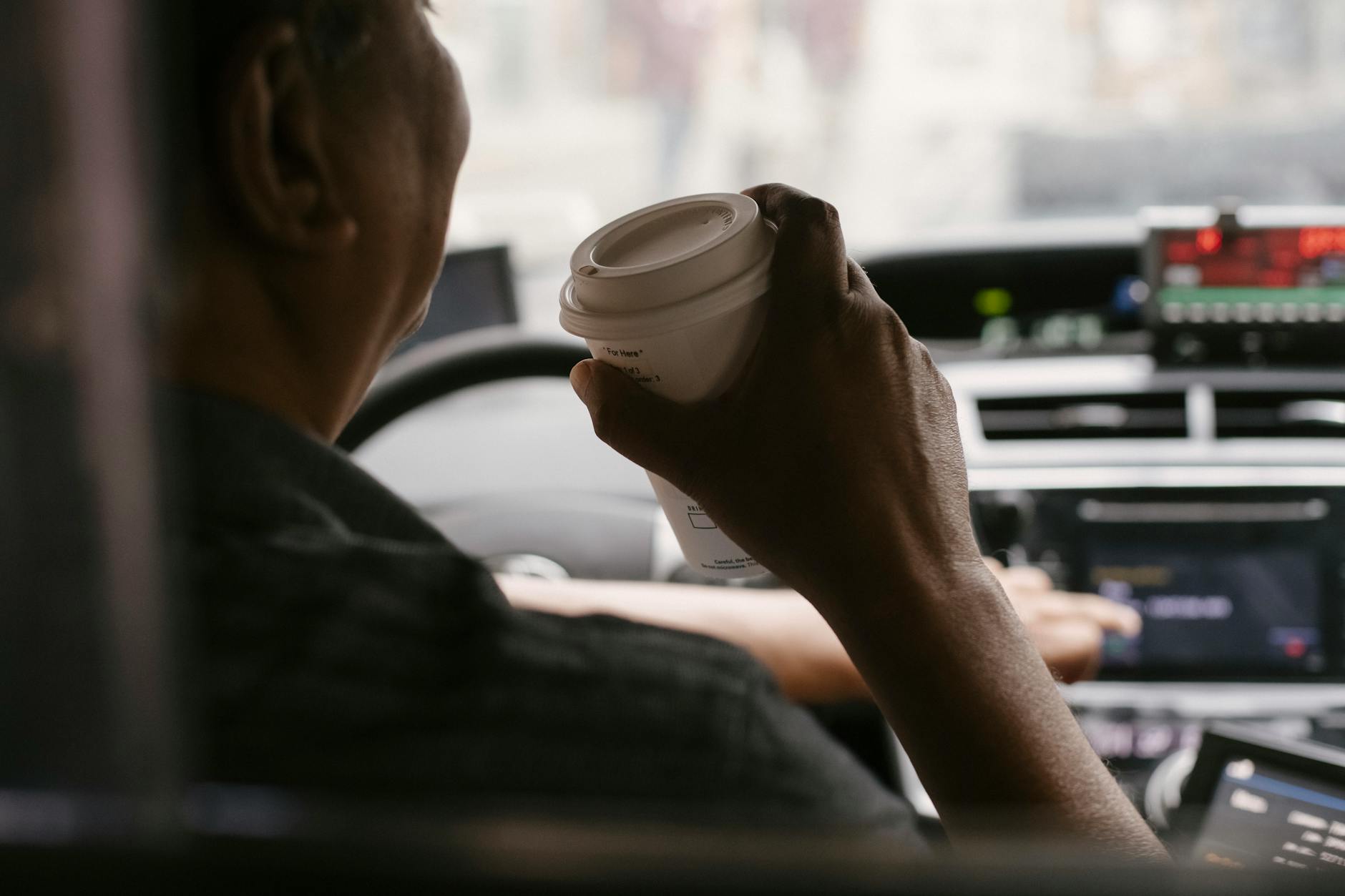 Cars lined up at a busy coffee shop drive-thru window with barista serving customers