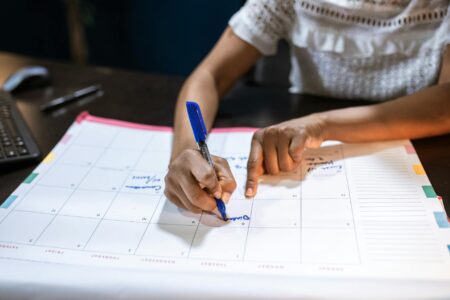Person planning content calendar with colorful sticky notes and markers on desk