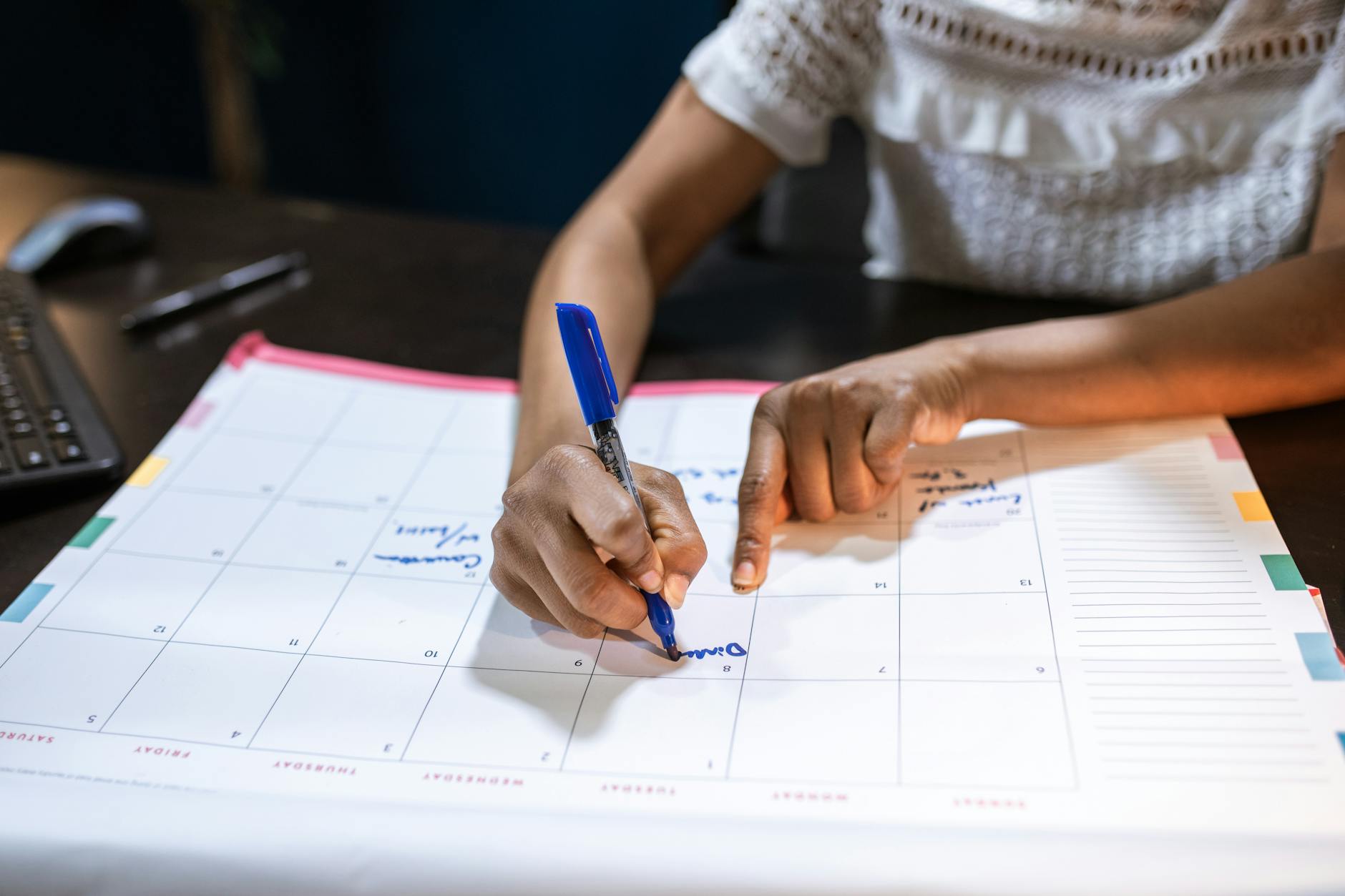 Person planning content calendar with colorful sticky notes and markers on desk
