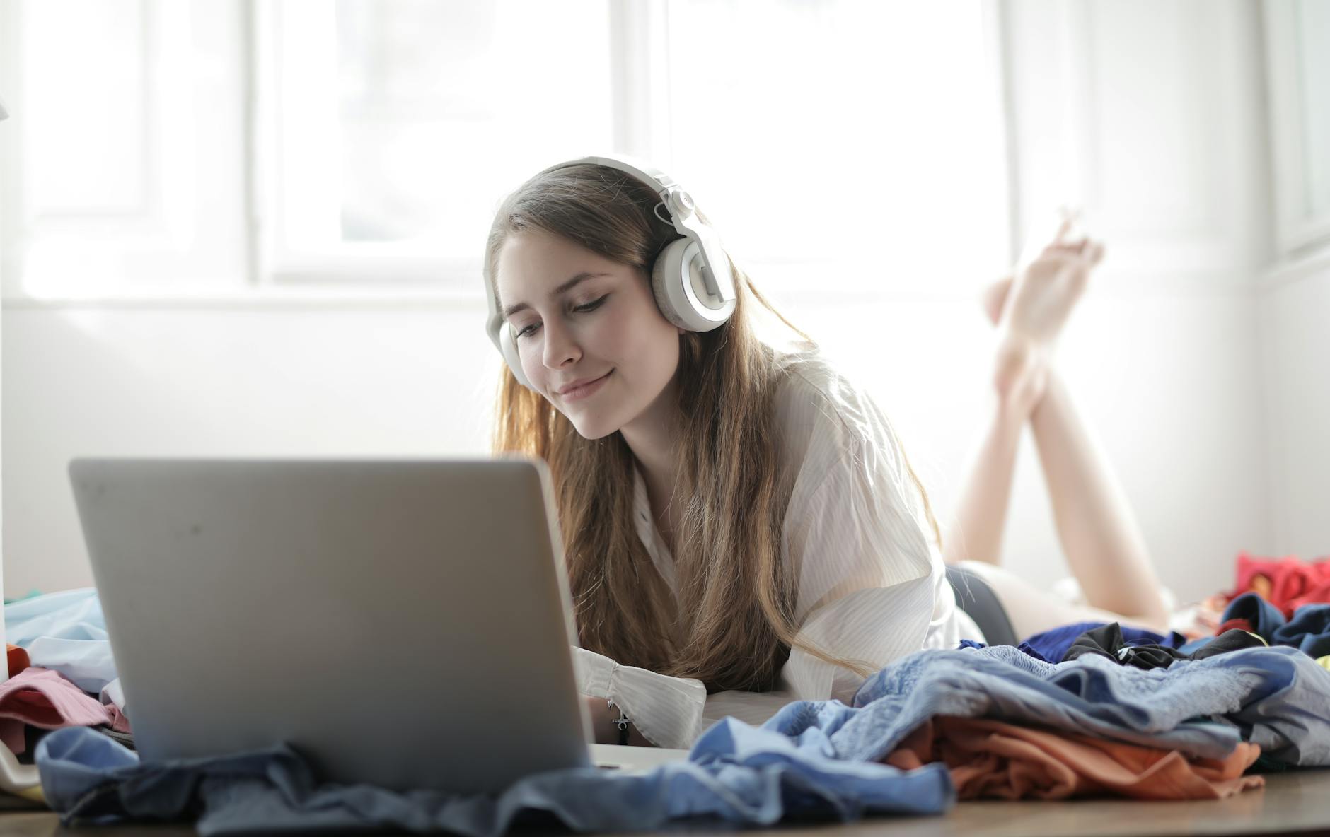 Person wearing headphones while working on laptop, representing audio advertising and digital marketing strategies