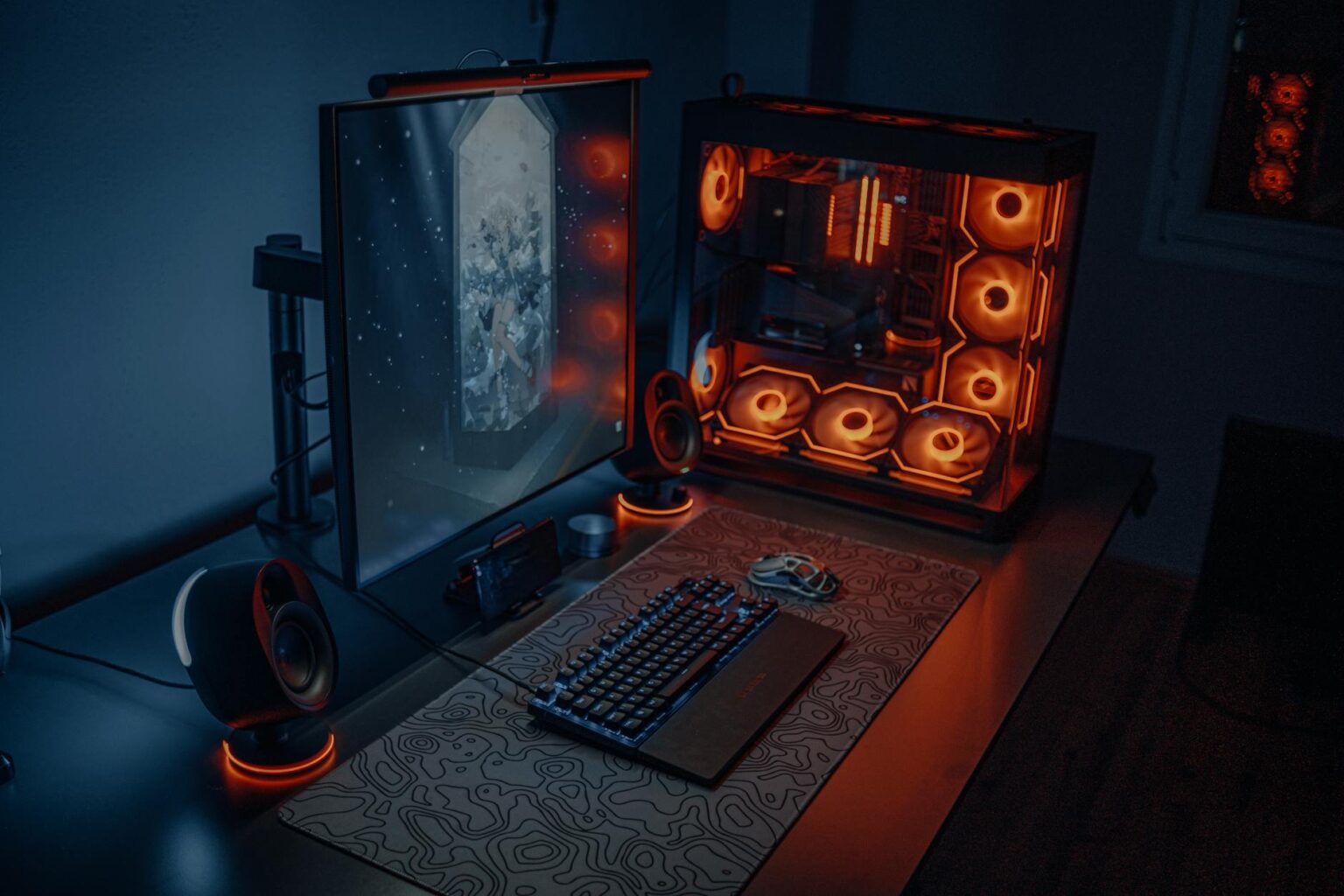 Modern gaming computer setup with multiple monitors displaying colorful interface elements