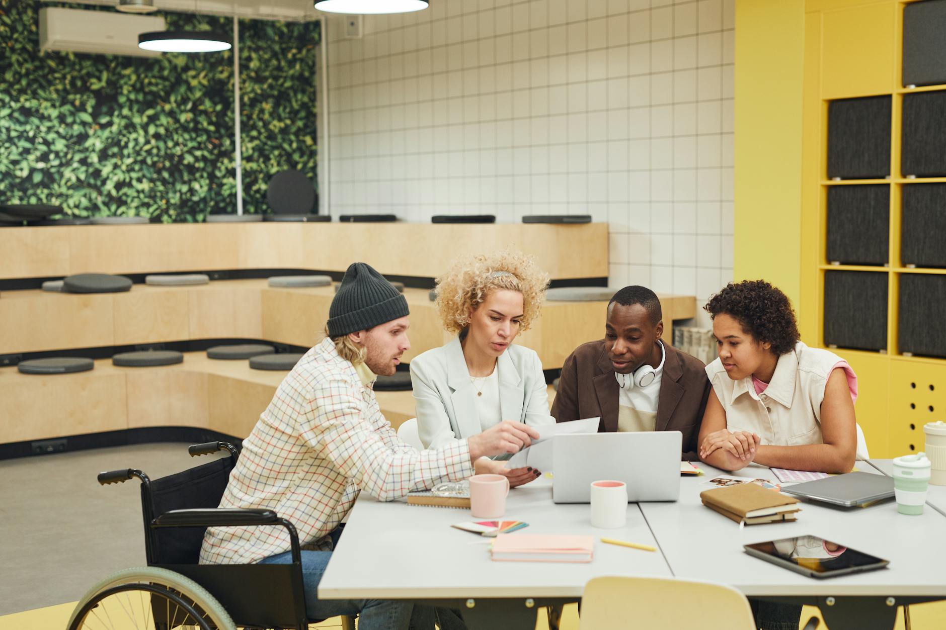 Business professionals collaborating around conference table reviewing digital marketing strategy documents
