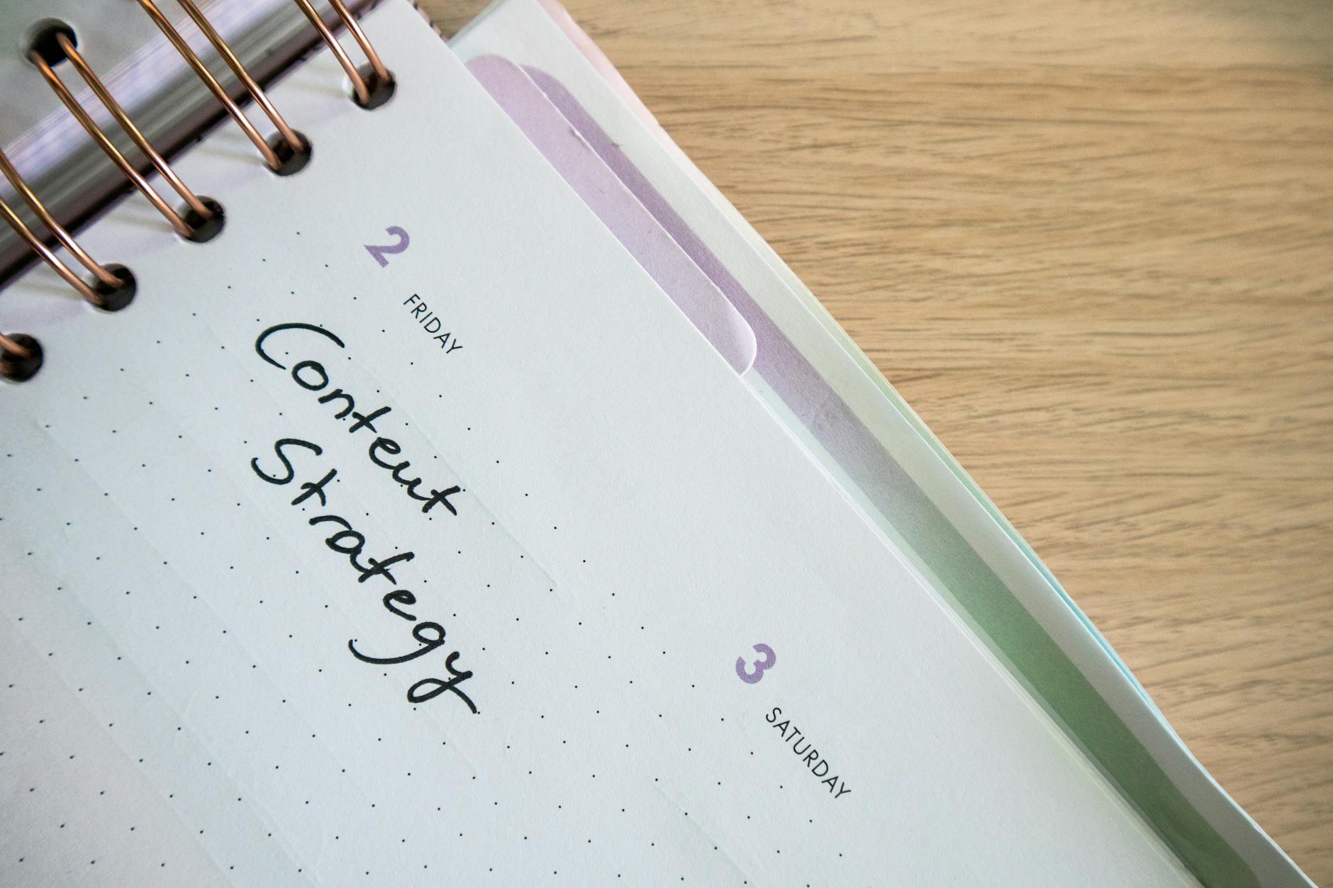 Person reviewing social media content calendar on laptop with sticky notes and marketing materials