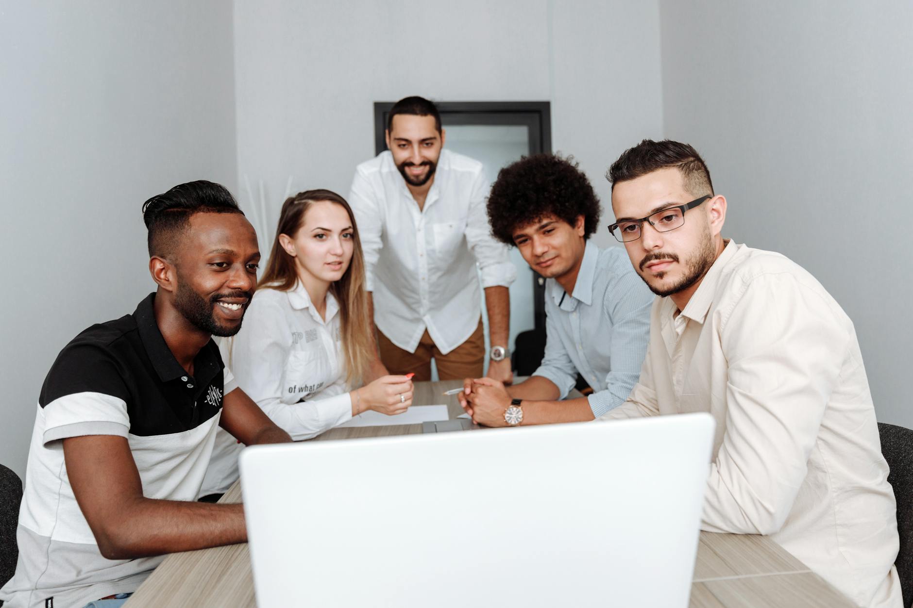 Business team collaborating around table with laptops and documents
