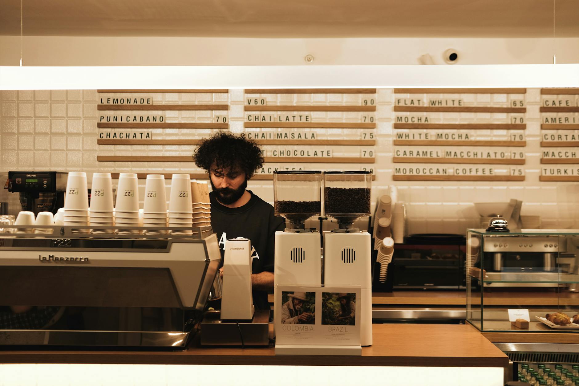 Modern coffee shop interior with customers using mobile devices for ordering