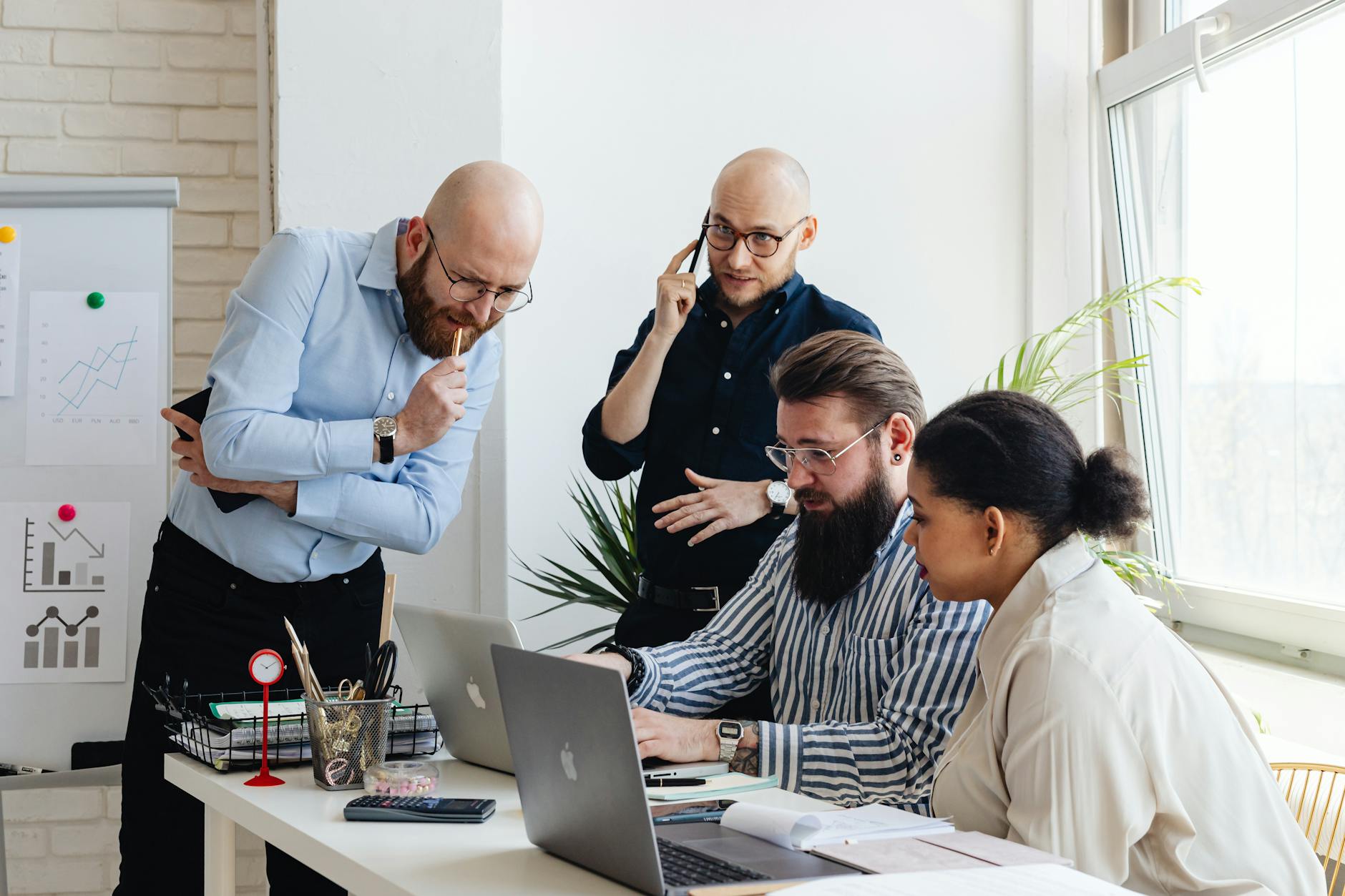 Business team collaborating around conference table with laptops and documents during strategy meeting