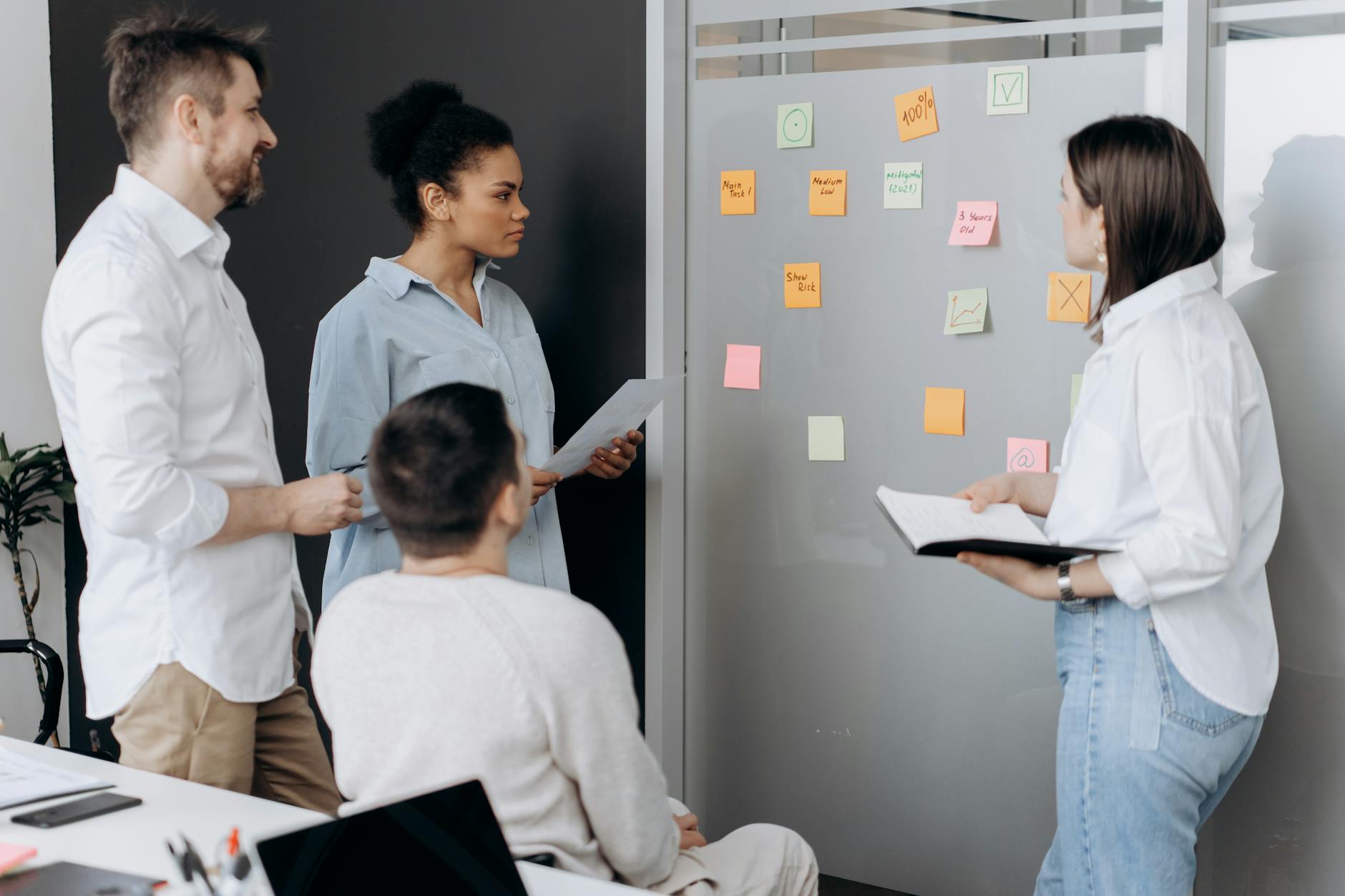 Marketing team collaborating around whiteboard with social media strategy notes