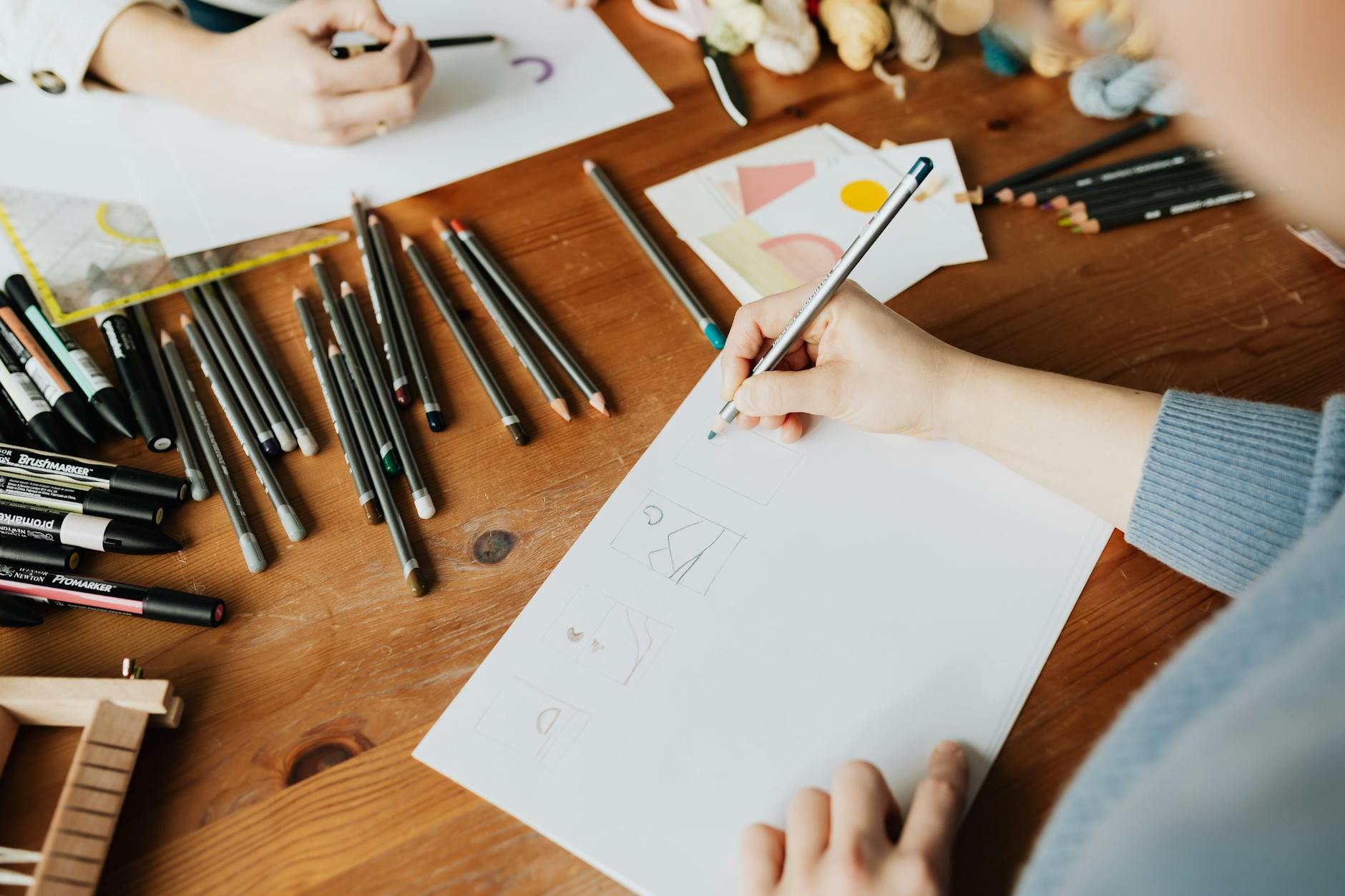 Designer creating visual content with graphics tablet and multiple design mockups on desk