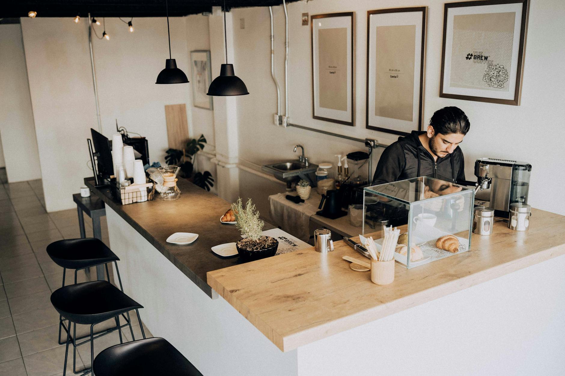 Modern coffee shop interior with customers and barista working behind counter