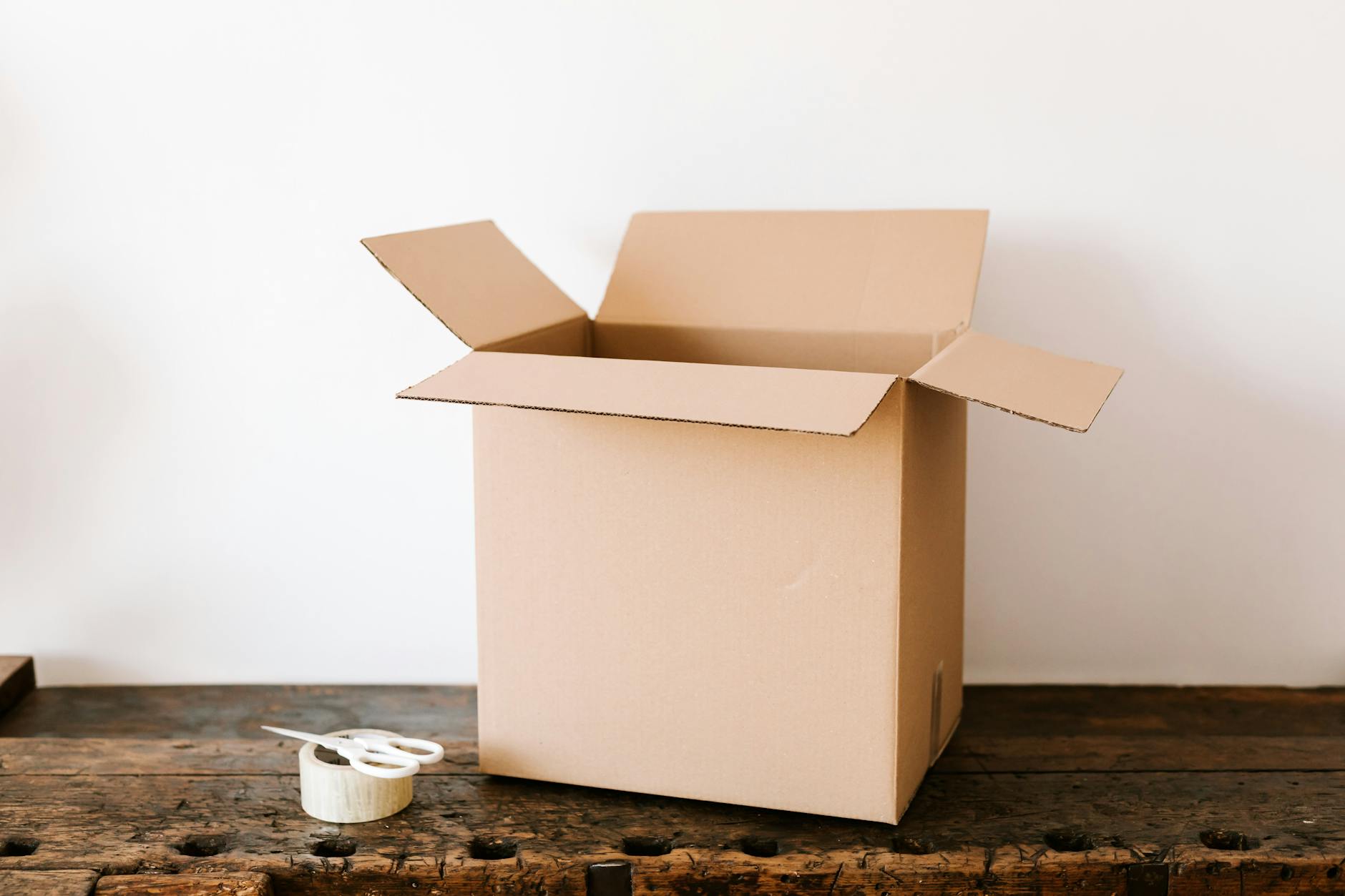 Branded shipping box being opened on a wooden table surface