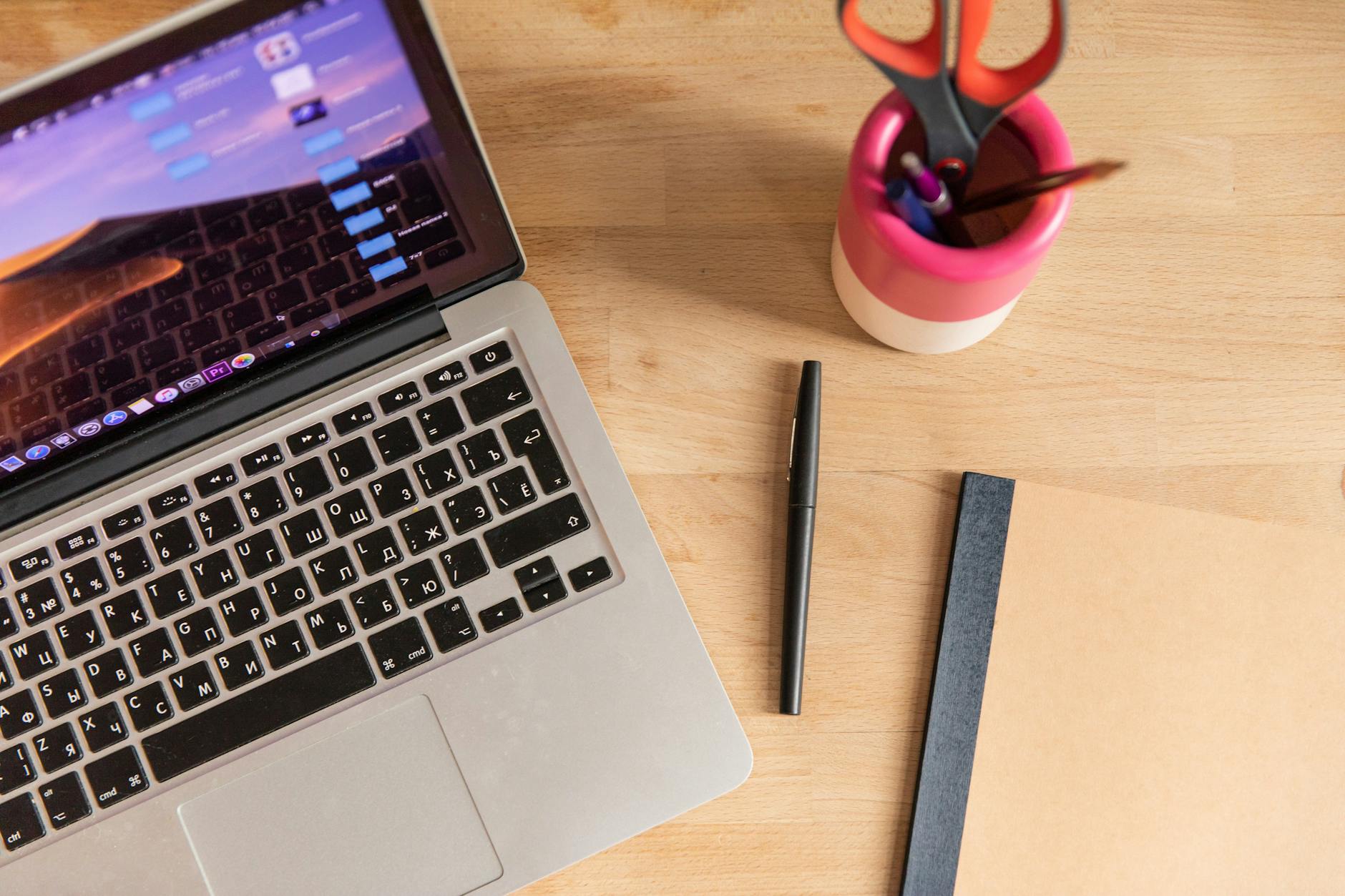 Modern workspace with laptop computer open to video analytics interface surrounded by coffee and notes