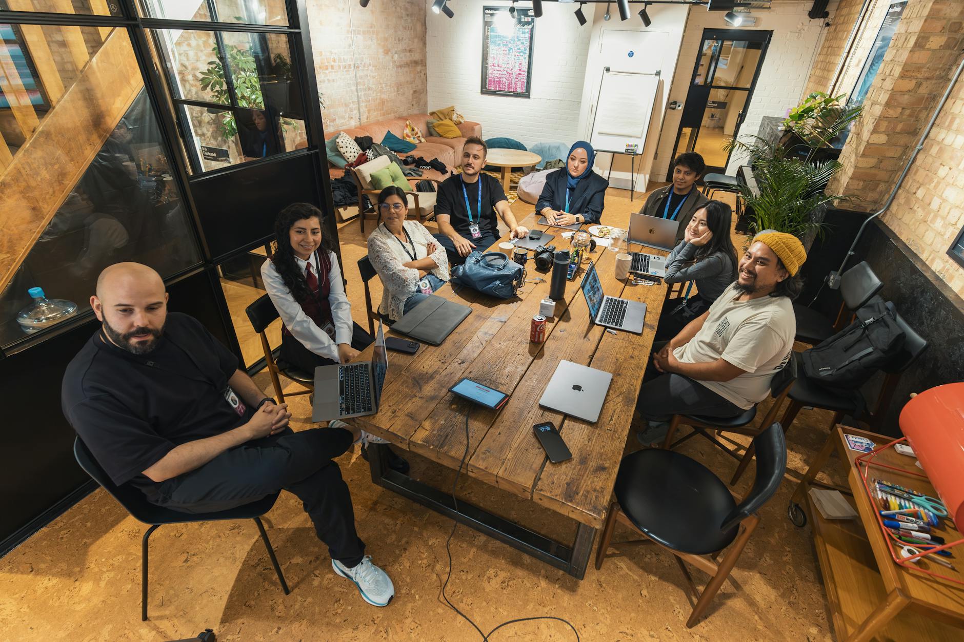 Business team collaborating around conference table with laptops