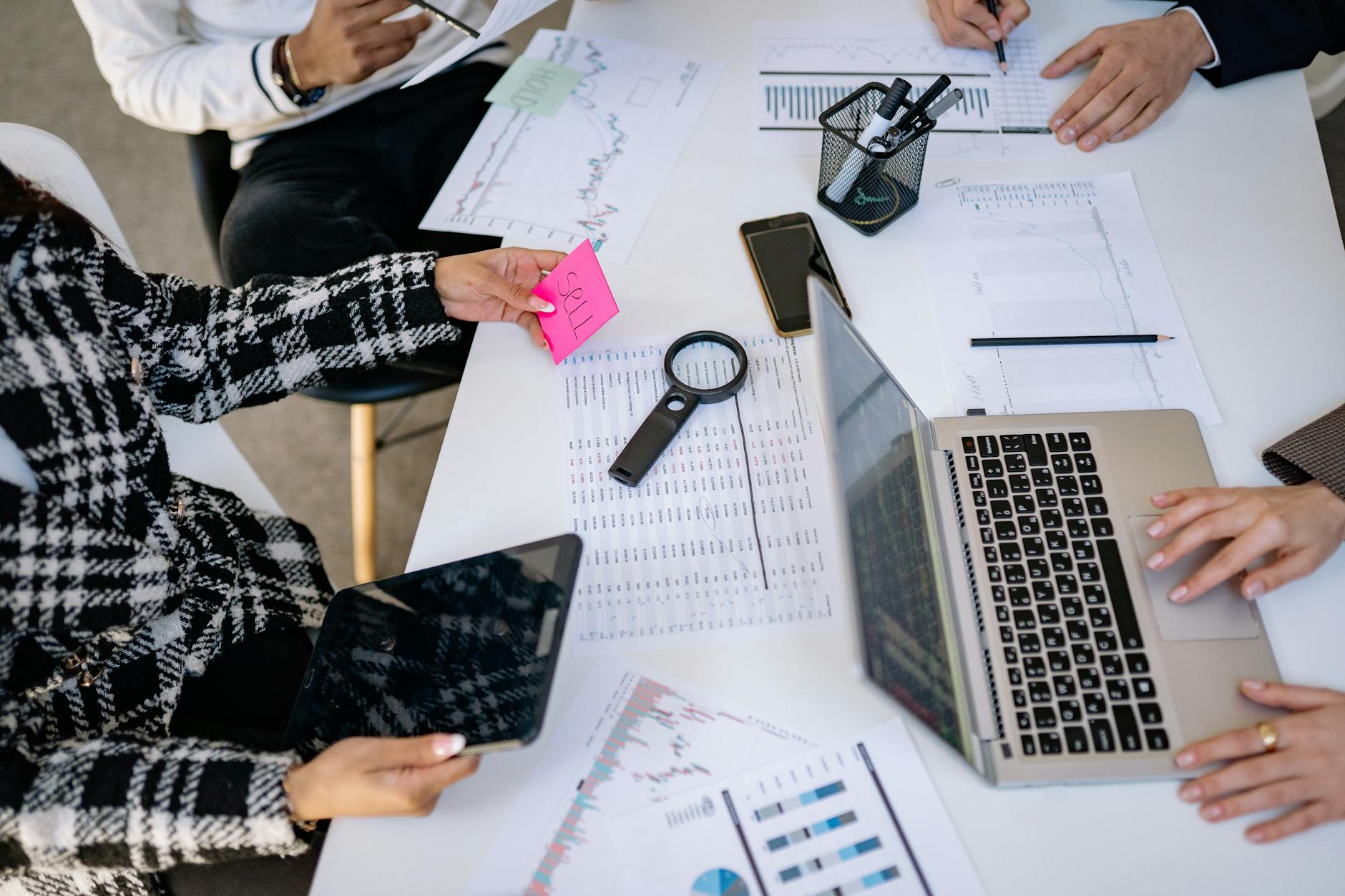 Marketing team discussing content strategy around conference table with laptops and documents