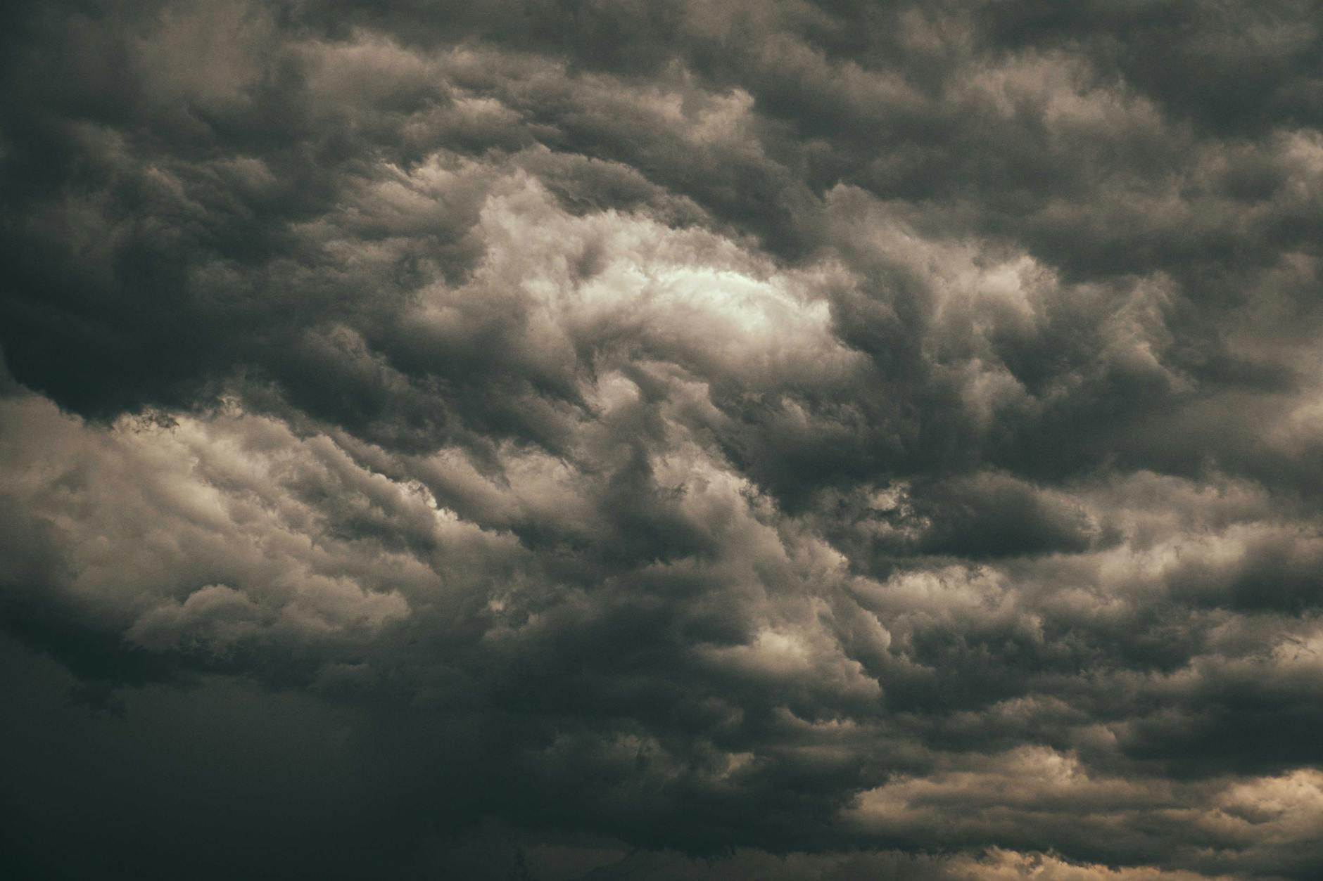 Dark storm clouds gathering over urban cityscape with buildings in foreground