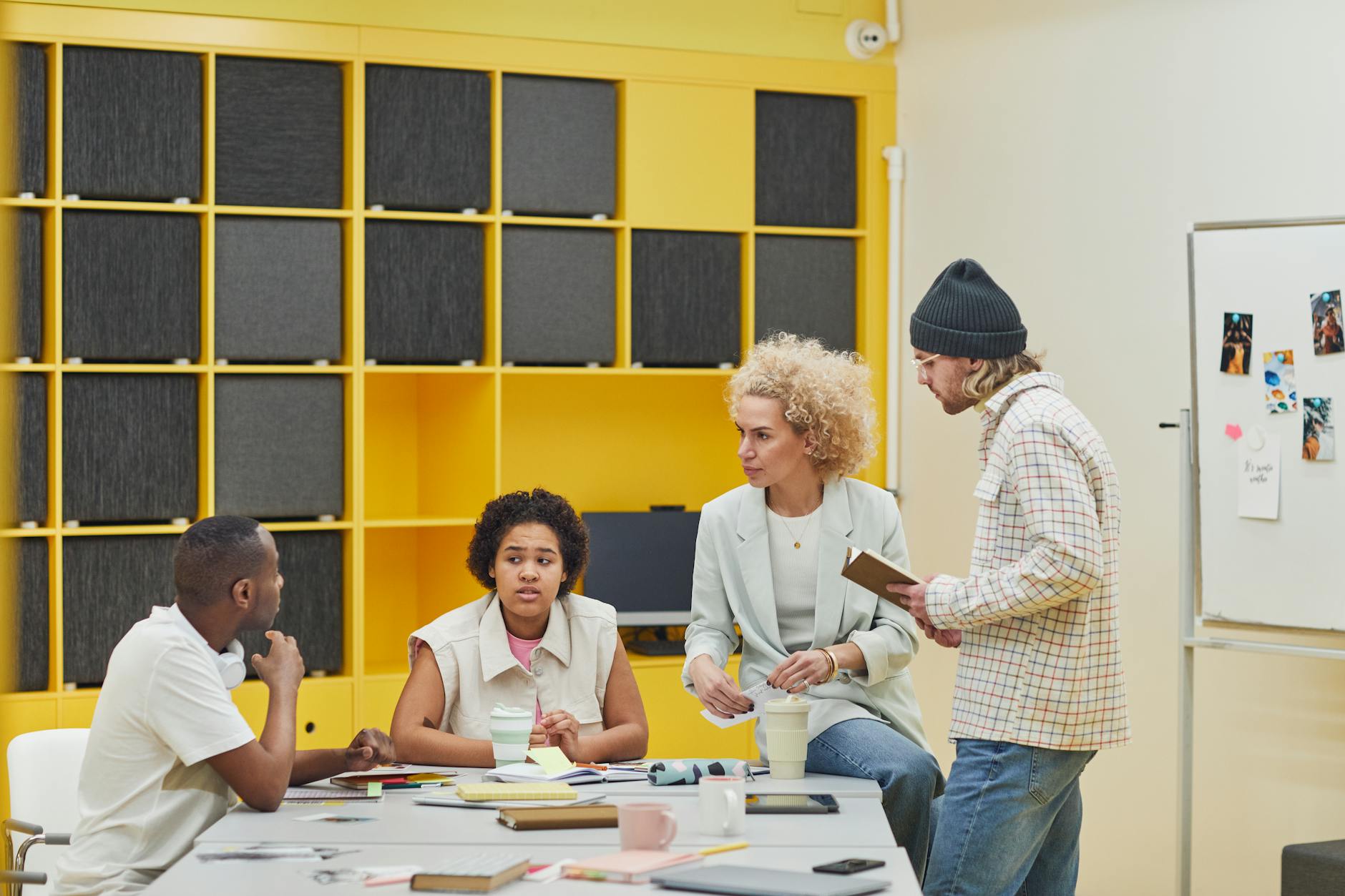 Professional team reviewing marketing data and visual content on office whiteboard