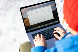 Person viewing analytics dashboard on laptop screen showing social media engagement metrics