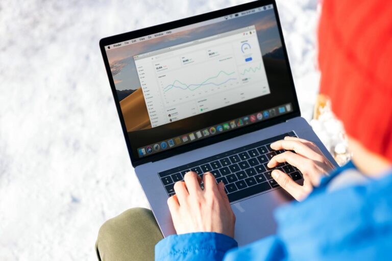 Person viewing analytics dashboard on laptop screen showing social media engagement metrics