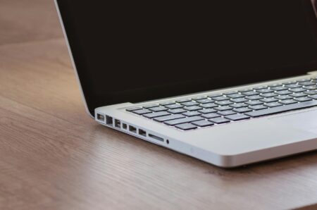 A professional working on a laptop, reviewing social media analytics on screen