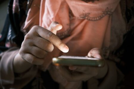 Young person scrolling through a social media feed on a smartphone