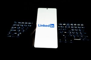Person scrolling LinkedIn feed on a smartphone showing poll content