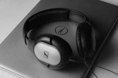 Person wearing headphones while working on laptop, representing playlist curation work