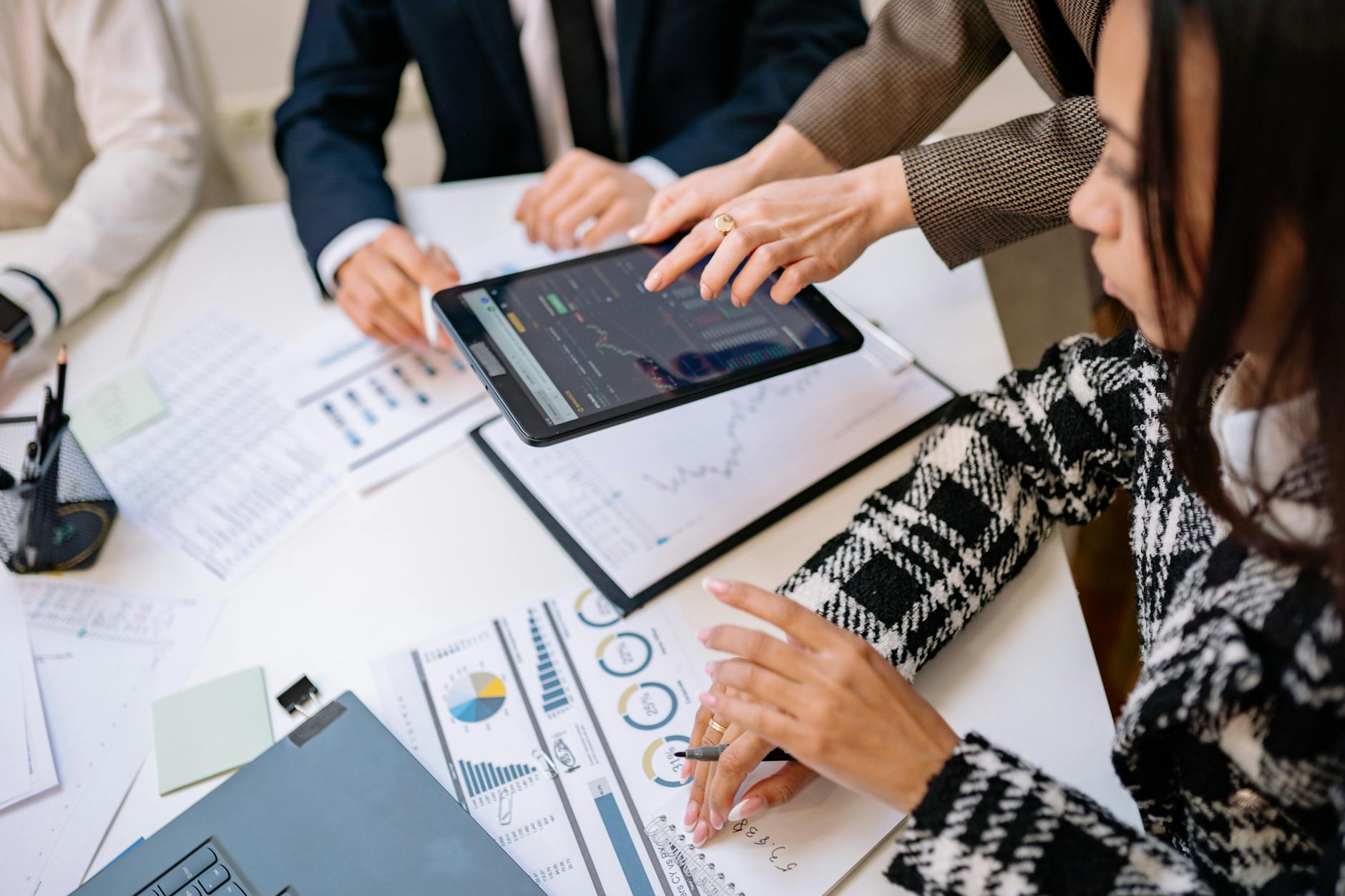 Small B2B marketing team reviewing campaign performance on a laptop in a conference room