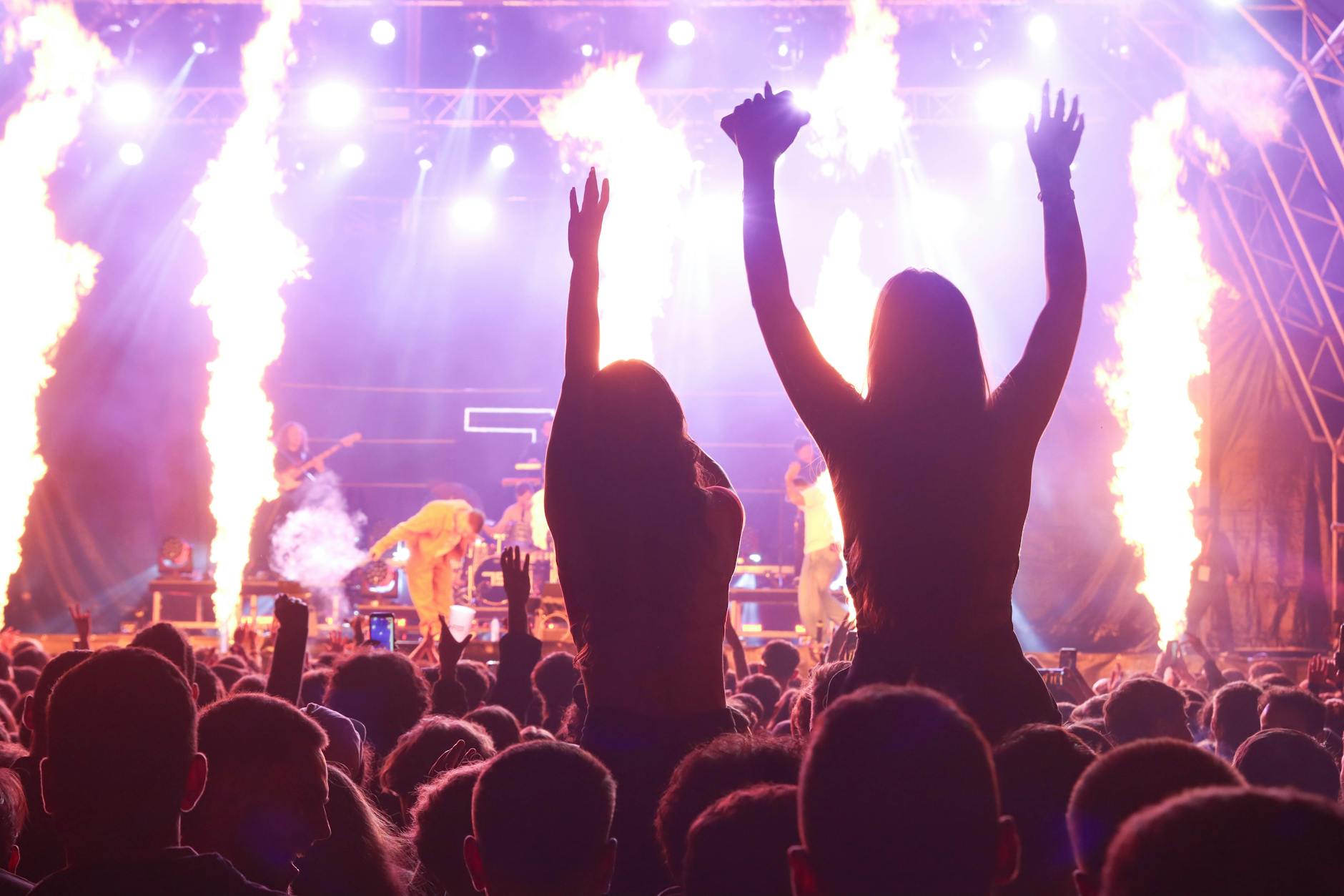 Concert audience with raised hands, showing live music event atmosphere