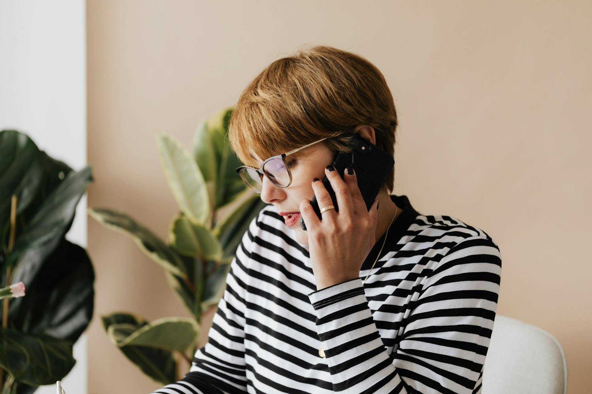 Business woman listening to audio content on her phone in a professional office environment
