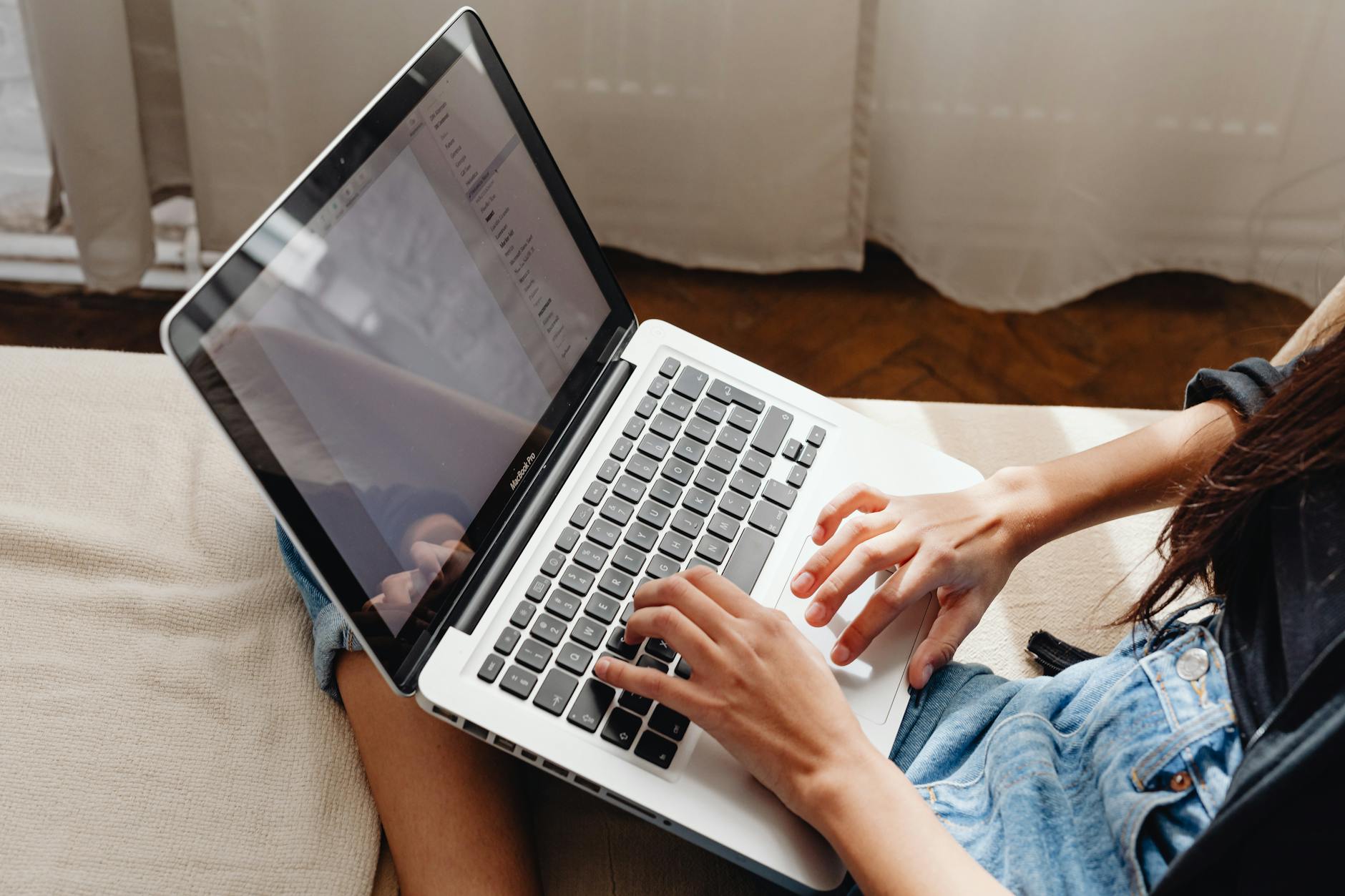 Person writing newsletter content on laptop with social media notifications visible