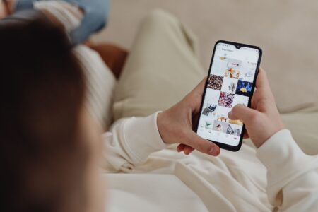 Person scrolling through Pinterest on a smartphone, browsing saved idea pins