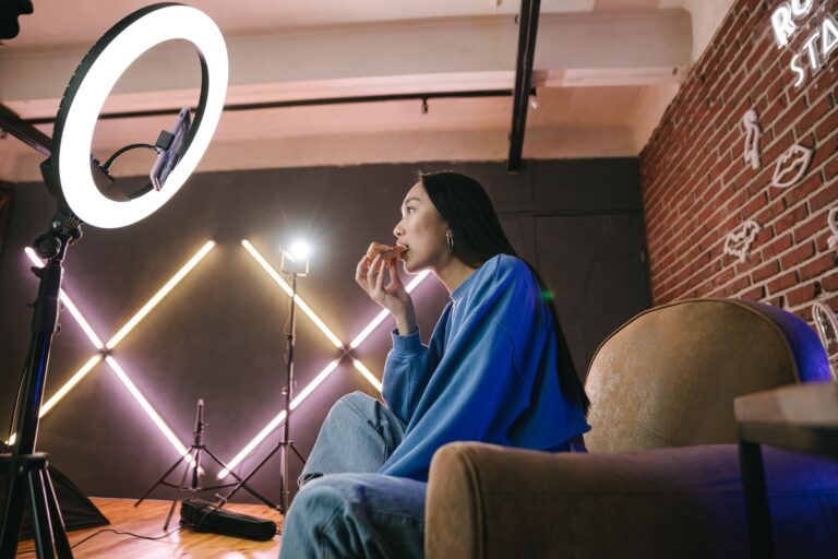 A content creator recording a live stream at a desk with multiple monitors