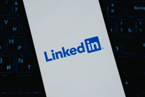Person scrolling LinkedIn on a smartphone showing video content in the feed