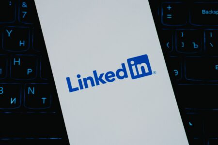 Person scrolling LinkedIn on a smartphone showing video content in the feed