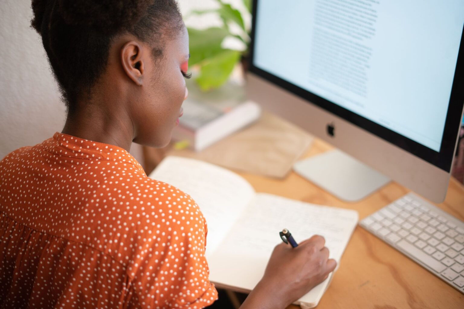 Person writing a newsletter on a laptop at a desk