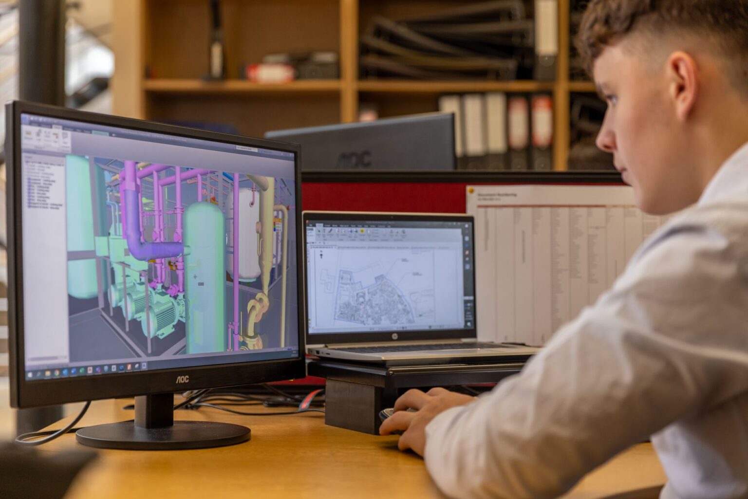 A designer working on a presentation layout on a desktop screen in a modern workspace