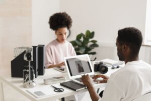 A content creator working at a clean desk setup with a laptop and scheduling tools open
