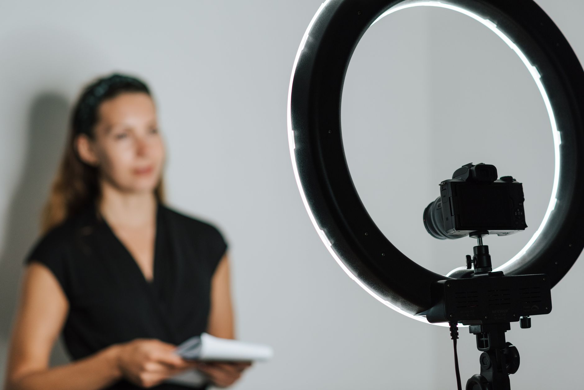 Content creator filming a live session with a smartphone and ring light setup