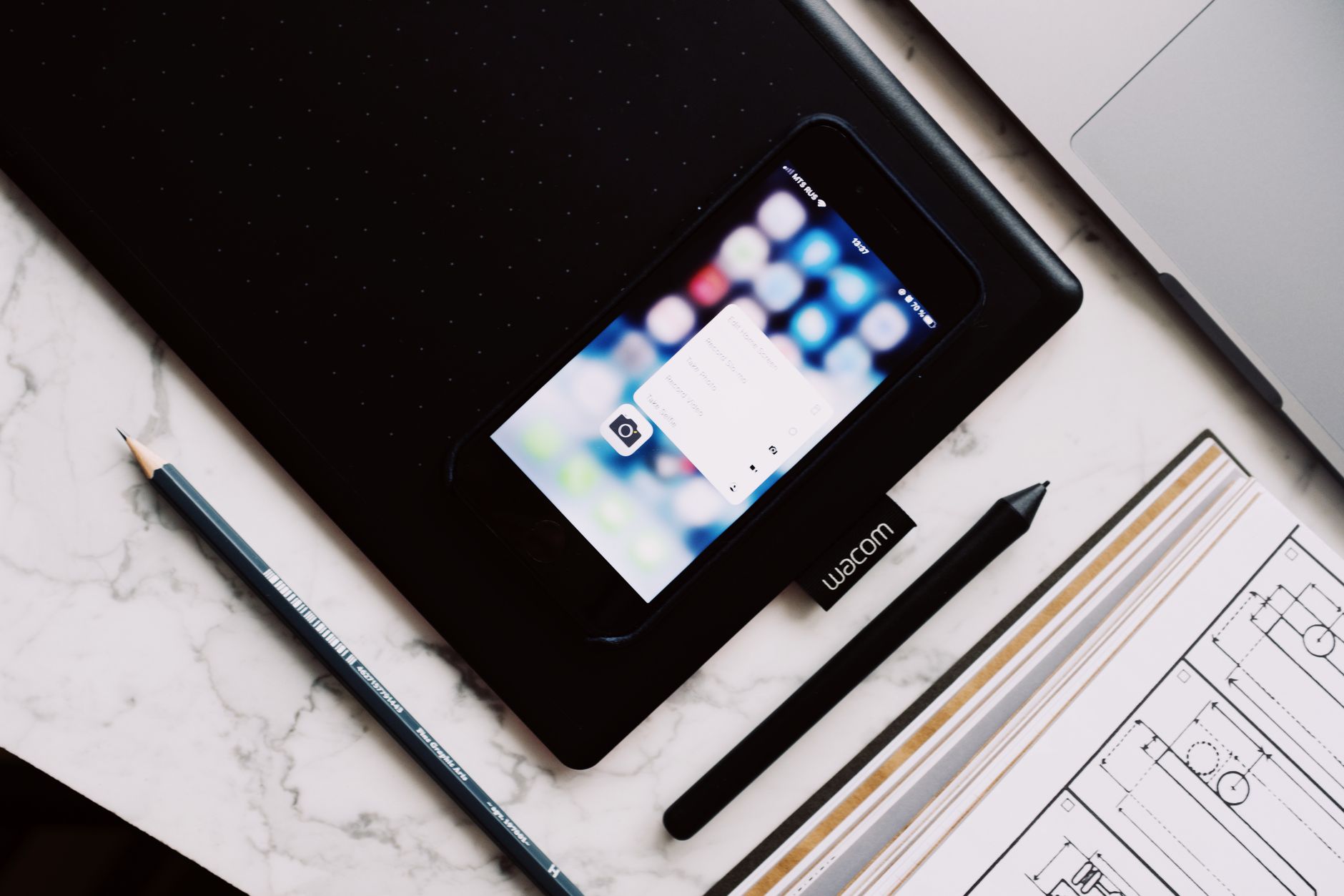 A designer working on a tablet with visual inspiration and layout tools on screen